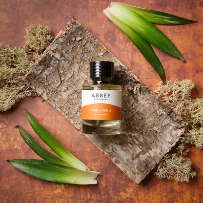 Terra Mirus perfume bottle on a bed of dry birch and oakmoss, surrounded by pineapple